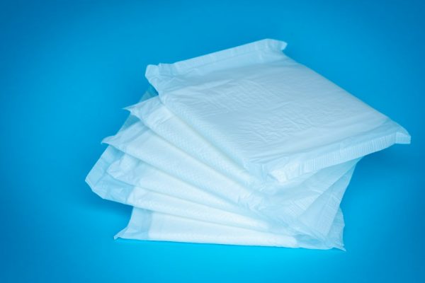 A pile of white absorbent pads on a blue table
