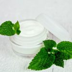 An open jar of skin cream on a white table