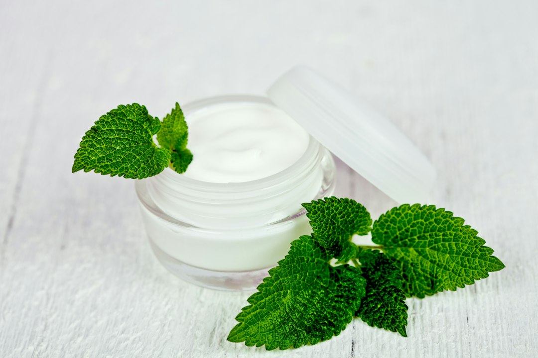 An open jar of skin cream on a white table
