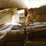 A pile of cotton and linen textiles in warm window light