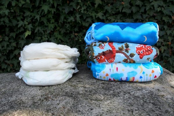 A disposable diaper laid beside a reusable cloth diaper for comparison