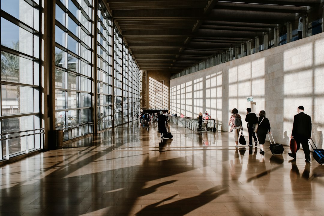 A traveler pulling a suitcase through an airport terminal